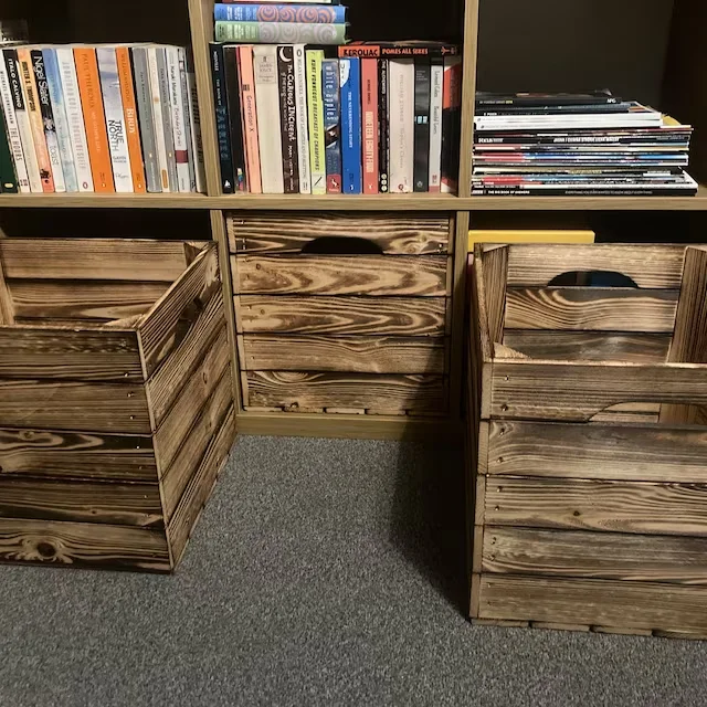 Burnt wooden crates under a bookshelf
