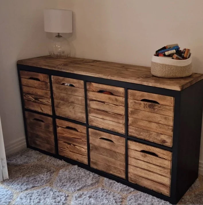 Burnt crates as drawers in a dark cube shelf