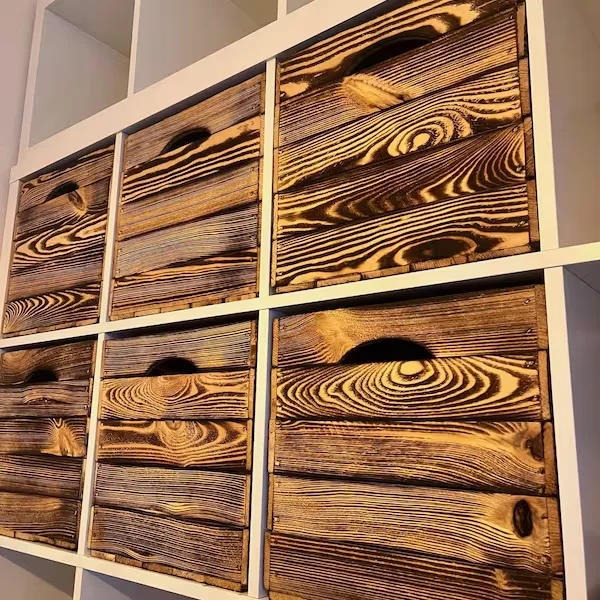Burnt crates with cut-out handles in the KALLAX shelf, close-up